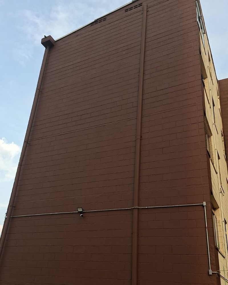 Empena de bloco residencial pintada, com tubulação e iluminação revisadas